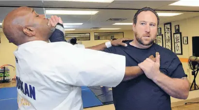  ?? JIM THOMPSON/JOURNAL ?? U.S. Air Force veteran Chris Sweetin, right, a partner in 3D Security & Training Solutions, works out with self-defense trainer Fred Sesler at BF Health Club in Rio Rancho.