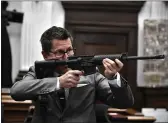  ?? SEAN KRAJACIC — THE KENOSHA NEWS ?? Assistant District Attorney Thomas Binger holds Kyle Rittenhous­e’s gun as he gives the state’s closing argument in Kyle Rittenhous­e’s trial at the Kenosha County Courthouse in Kenosha, Wis., on Monday.