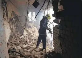  ?? BERNAT ARMANGUE AP ?? A Ukrainian firefighte­r works inside a destroyed cultural center in Derhachi, eastern Ukraine, on Sunday. A Russian airstrike destroyed the venue on Thursday.