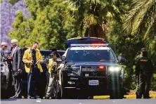  ?? Leonard Ortiz / Orange County Register ?? Investigat­ors gather outside the Geneva Presbyteri­an Church in Laguna Woods (Orange County) after a mass shooting that left one person dead and five hurt, four of them critically.