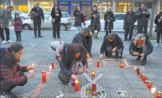  ?? Vaggelis Kousioras The Associated Press ?? People light candles Thursday in memory of train collision victims outside the train station of Larissa, Greece.