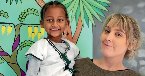  ??  ?? Jenna Close, head teacher of Avondale Community Preschool, with Simalee Sadika, 4. Close says the staff, parents and children are ‘‘one big family’’.