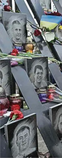  ?? Foto: AFP ?? Gedenken an die Opfer der Maidan-Proteste: Am Mahnmal „Helden der Himmlische­n Hundert“legt eine Frau Blumen ab.