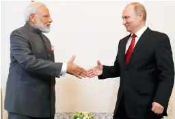  ?? — PTI ?? Russian President Vladimir Putin shakes hands with Prime Minister Narendra Modi prior to their talks at the Internatio­nal Economic Forum in St. Petersburg, Russia, on Thursday.