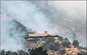  ?? ROBYN BECK/GETTY-AFP ?? A fire crew on Tuesday makes its way to a house surrounded by smoke from the Thomas fire, the fifth largest fire in California history, in Montecito, just outside Santa Barbara.