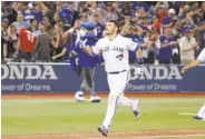  ?? Tom Szczerbows­ki / Getty Images ?? Toronto’s Luke Maile tosses his helmet after his game-winning, two-run homer against Boston.