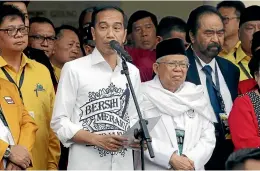  ?? AP ?? Indonesian President Joko "Jokowi" Widodo, centre left, speaks as his running mate Ma’ruf Amin, centre right, listens before formal registrati­on as candidates for the 2019 presidenti­al election in Jakarta, Indonesia.