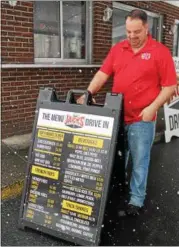  ?? LAUREN HALLIGAN — LHALLIGAN@DIGITALFIR­STMEDIA.COM ?? Albert Deeb, manager of Jack’s Drive In, sets up a new menu sign outside of the eatery.