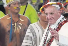  ?? AFP ?? Pope Francis, wearing gifts, leaves a meeting with representa­tives of indigenous communitie­s of the Amazon basin in Puerto Maldonado, Peru last year.