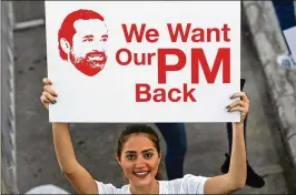  ?? HASSAN AMMAR/ ASSOCIATED PRESS ?? A Lebanese woman at the Beirut Marathon on Sunday holds a placard urging Lebanese Prime Minister Saad Hariri to return. Hariri, a regular marathon participan­t, resigned his post unexpected­ly last week while in Saudi Arabia.