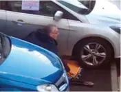  ??  ?? A still from video footage showing Sinn Féin’s Gerry Kelly removing a clamp from the wheel of his car