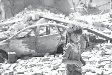  ?? Associated Press ?? An Iraqi girl flees through a destroyed street on Sunday as Iraqi Special Forces continue their advance against Islamic State militants in the Old City of Mosul, Iraq.