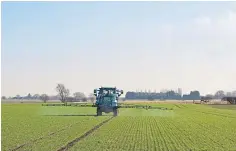  ??  ?? A tractor-mounted crop-sprayer at work in a wheat field.