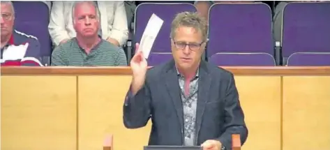  ??  ?? Developer Rainer Hummel, in this image taken from a Niagara Region video, holds an envelope during an audit committee meeting, he said contained a cheque for $50,000 to pay for an audit of the Town of Pelham finances.