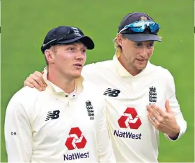  ??  ?? Words of encouragem­ent: Joe Root speaks to Dom Bess as they walk off for a rain delay