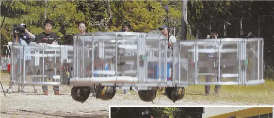  ?? AP PHOTOS ?? IT'S A HEAVY LIFT: Tsubasa Nakamura, second from left in the photo above, is project leader for Cartivator, a startup in which Toyota invested $386,000. He is watching the flight of a test model of a flying car yesterday on a former school playground...