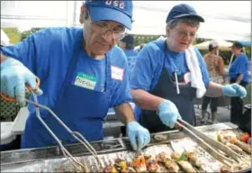  ?? Souderton Independen­t photos — SUSAN KEEN ?? Michael Ibrahim, left, and Joanne Wiszneski grill kabobs during St. Philip’s Internatio­nal Food Festival Sept. 22 at St. Philip’s Antiochian Orthodox Church in Souderton.