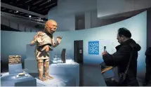  ?? EPA-Yonhap ?? A man takes a picture of the sculpture of Mictlantec­uhtli, god of death in the Mexica culture, displayed at the exhibition “Mexica. Des dons et des Dieux au Templo Mayor” during a press tour at the Quai Branly museum in Paris on April 2.