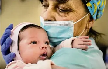  ?? Lynsey Addario / New York Times ?? Svitlana Stetsiuk, 50, helps to care for one of 19 babies born to Ukrainian surrogate mothers, now sheltered during the Russian invasion at a basement nursery in Kyiv, Friday. Due in part to relatively permissive laws and poverty, Ukraine had what was by some estimates the world’s biggest surrogacy industry. Now, many newborns are facing an uncertain fate.