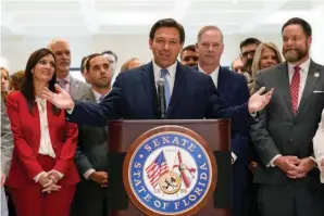  ?? The Associated Press ?? ■ Surrounded by lawmakers, Florida Gov. Ron DeSantis speaks at the end of a legislativ­e session, on April 30 at the Capitol in Tallahasse­e, Fla.