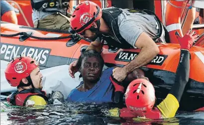  ?? PAU BARRENA / AFP ?? Miembros de Proactiva Open Arms rescatan a una supervivie­nte en estado de shock