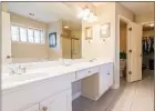  ??  ?? The tiled master bath features a two-sink vanity, a jetted tub, a separate shower and a walk-in closet.