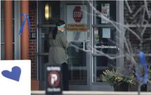  ?? CLIFFORD SKARSTEDT EXAMINER ?? Blue ribbons and hearts honour and thank front-line health-care workers during the COVID-19 pandemic as a worker enters St. Joseph’s at Fleming on Wednesday.