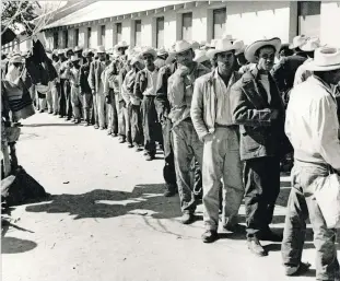  ?? NATIONAL TRUST FOR HISTORIC PRESERVATI­ON VIA AP ?? Workers wait in line to be contracted at the Rio Vista Farm Reception Center in Socorro, Texas. During peak times at Rio Vista Farm, up to 1,500 men signed short-term labor contracts to assist with labor shortages across the country.