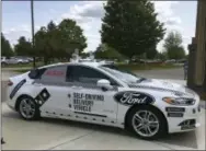  ?? THE ASSOCIATED PRESS ?? The specially designed delivery car that Ford Motor Co. and Domino’s Pizza will use to test self-driving pizza deliveries is parked at Domino’s headquarte­rs in Ann Arbor, Mich.