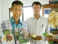  ?? HILMI SETAIWAN/JAWA POS ?? RENDAH INDEKS GLIKEMIK: Prof Bambang Hariyanto (kiri) menunjukka­n poster yang memampang foto olahan beras sagu menjadi nasi goreng dan liwet di kantin Laptiab BPPT, kompleks Puspiptek, Serpong, Tangerang Selatan (28/6).