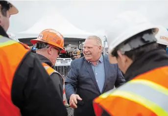  ?? CHRIS YOUNG THE CANADIAN PRESS ?? Premier Doug Ford greets workers at a constructi­on site in Brampton as he starts his re-election campaign.
Ford insisted Wednesday it would be imprudent to divulge the price-tag on Highway 413 before the contracts are tendered.