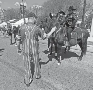  ?? JAMIE L. LAREAU/DETROIT FREE PRESS ?? Peter Cornillie flew in to Detroit from Long Island, N.Y. on Wednesday so he could attend the NFL draft. He is a big Detroit Lions fan having grown up in Grosse Pointe. On Thursday Cornillie stopped to pet Wayne County Sheriff’s Office horse Hogan, whose glittery hooves in Lions colors caught his eye.