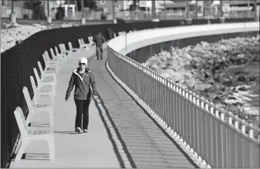  ?? SEAN D. ELLIOT/THE DAY ?? Karen Anastasiou, of East Lyme, takes a walk Monday along the Niantic Bay Boardwalk. Anastasiou says she walks the boardwalk often, listening to podcasts and audio books, but “more in the summer.”