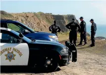  ??  ?? California Highway Patrol officers and deputy sheriffs from Mendocino and Alameda counties gather after a search for three missing children at the site where the bodies of Jennifer and Sarah Hart and three of their adopted children were recovered two...