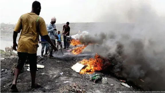  ?? Bild: The Yomiuri Shimbun/AP Photo/picture alliance / ASSOCIATED PRESS ?? Diese Männer nahe Accra in Ghana wollen an Kupferkabe­l gelangen und verbrennen Elektrosch­rott unter freiem Himmel - der Qualm gelangt ungehinder­t in die Atmosphäre