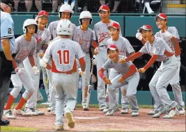  ?? Gene J. Puskar ?? The Associated Press Japan’s Keitaro Miyahara (10) is greeted by teammates after hitting a solo home run off Lufkin, Texas, pitcher Chip Buchanan in the fourth inning of the Little League World Series Championsh­ip game Sunday in South Williamspo­rt, Pa.