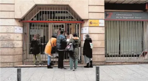  ?? REUTERS ?? Varias personas, en la puerta de una oficina de la Administra­ción de la Seguridad Social en Madrid