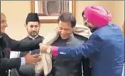 ?? ANI ?? Punjab minister Navjot Singh Sidhu offering a shawl to newly swornin Pakistan Prime Minister Imran Khan in Islamabad.
