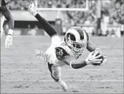  ?? Robert Gauthier Los Angeles Times ?? ROBERT WOODS dives into the end zone for his second third-quarter touchdown against the Texans.