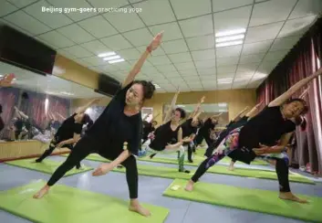  ??  ?? Beijing gym-goers practicing yoga