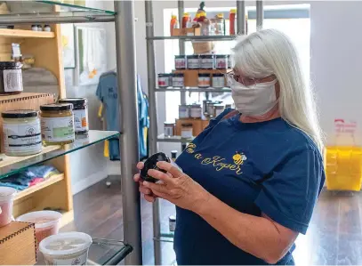  ?? Gazette photo by Sara Vaughn ?? ■ Jane Collums wears her mask while shopping at The Mustard Seed on Texas Blvd. Collums is a beekeeper and honey vendor for the store.