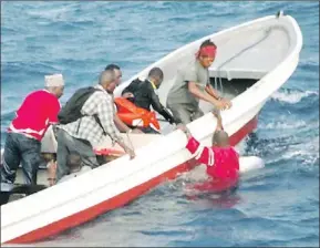  ?? — Photo by The Associated Press ?? A survivor of the Zanzibar ferry accident is pulled from the sea into a boat by a rescue team Thursday.
