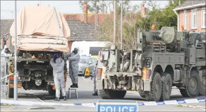  ?? AP PHOTO ?? Soldiers wearing protective clothing lift a tow truck in Hyde Road, Gillingham, Dorset, England as the investigat­ion into the suspected nerve agent attack on Russian double agent Sergei Skripal continues Wednesday.