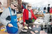  ??  ?? Mansueto Siorpaes with his Canadian-born wife Joanne, staffs the outdoor grill at the couple’s Col Taron restaurant, catering to skiers on the slopes of Cortina.