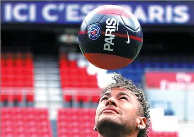  ?? CHRISTIAN HARTMANN / REUTERS ?? New Paris Saint-Germain signing Neymar juggles the ball at his unveiling at Parc des Princes on Friday.