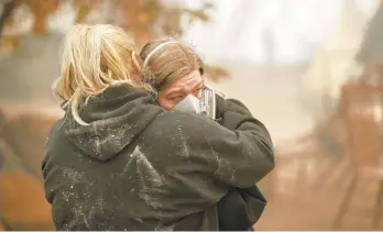  ?? JOHN LOCHER/AP ?? Krystin Harvey (left) comforts her daughter, Araya Cipollini, Saturday at the remains of their home burned in the Camp Fire in Paradise, Calif. The blaze has destroyed more than 6,700 buildings.
