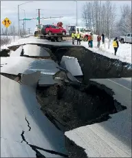  ?? AP PHOTO MIKE DINNEEN ?? A tow truck holds a car Friday that was pulled from on an off-ramp that collapsed during a morning earthquake in Anchorage, Alaska. The driver was not injured. Back-to-back earthquake­s measuring 7.0 and 5.8 rocked buildings and buckled roads, prompting people to run from their offices or seek shelter under desks, while a tsunami warning had others seeking higher ground.