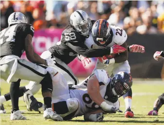  ?? Ezra Shaw / Getty Images ?? Raiders linebacker Neiron Ball (58) puts the pressure on Denver’s C.J. Anderson (22) in the fourth quarter last Sunday. The rookie played 36 snaps and shut down tight end Owen Daniels.