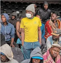  ?? JEROME DELAY THE ASSOCIATED PRESS ?? Homeless people are seen at the Caledonian Stadium in downtown Pretoria, South Africa, on Thursday after being rounded up by police in an effort to enforce a 21-day lockdown.