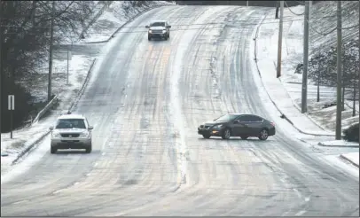  ?? The Sentinel-Record/Richard Rasmussen ?? ICY ROADS: Motorists head down the 1700 block of Malvern Avenue, which was slick with ice and snow, Tuesday morning. All seven public school districts in the county, along with county government offices, closed due to the inclement weather.